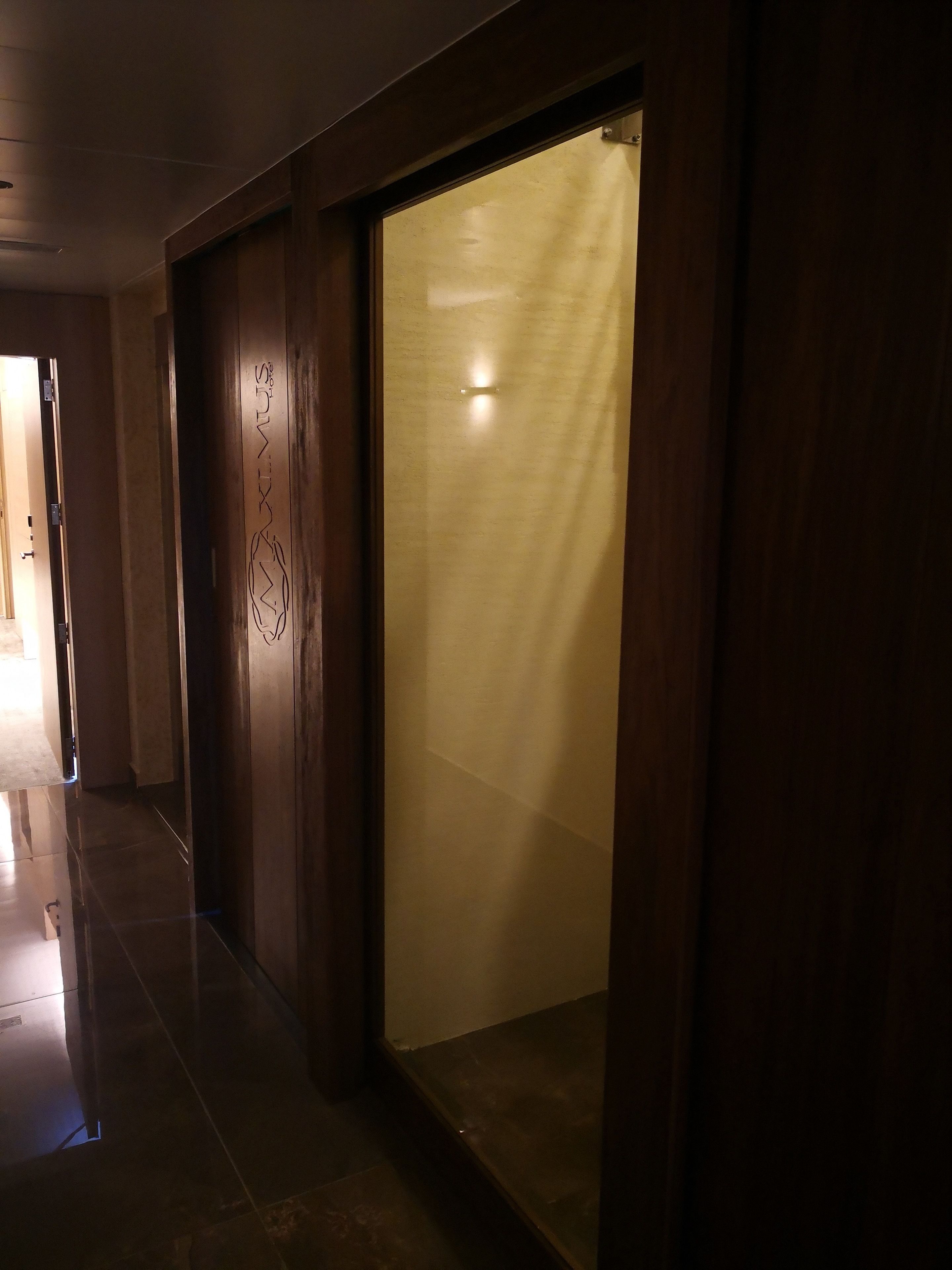 A hallway with wooden doors and a glass partition.