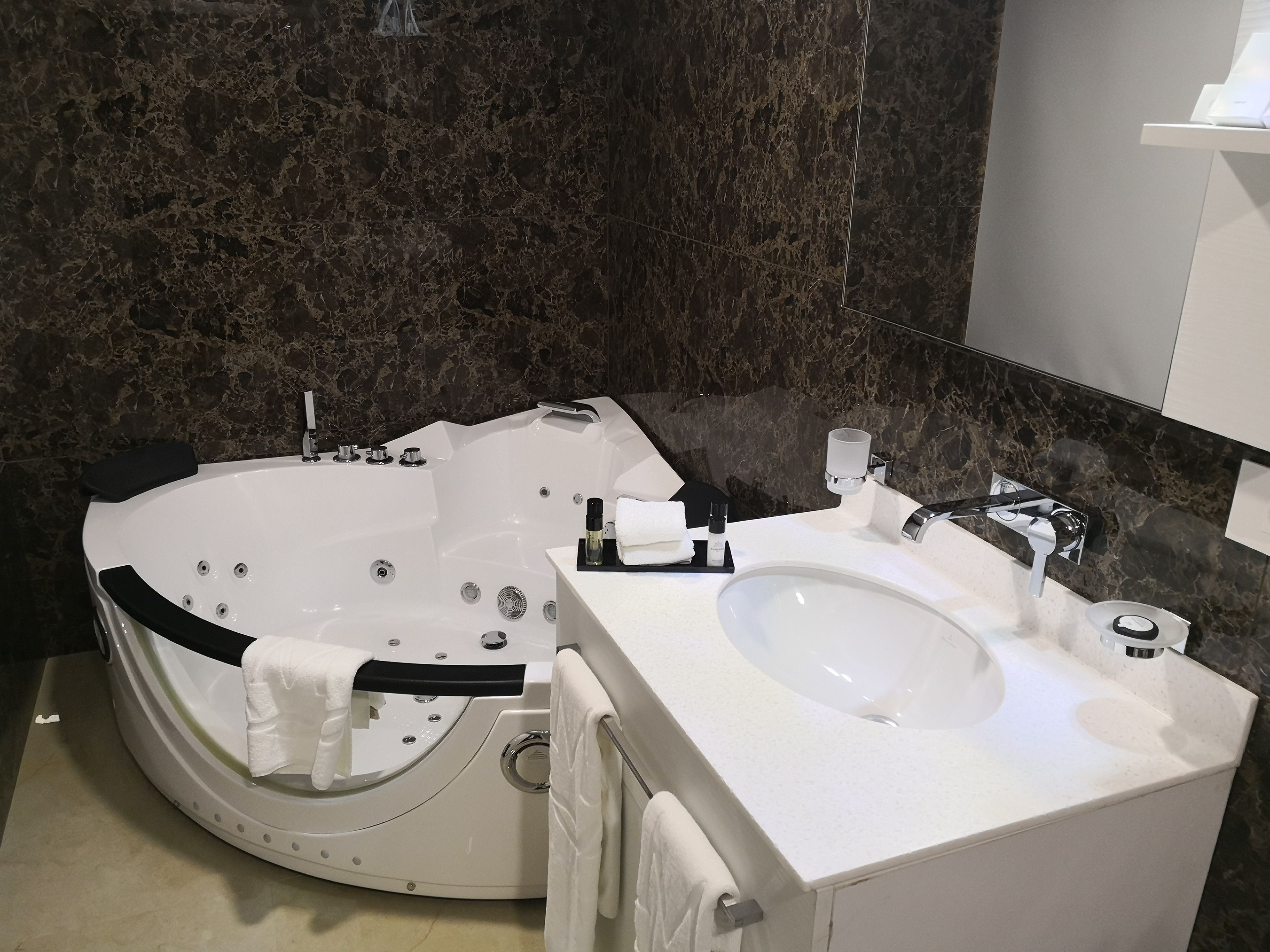 A modern bathroom with a freestanding bathtub, a sink, and a mirror.