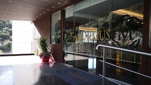 A hotel entrance with a glass facade, a metal handrail, and a doormat with the hotel's name. - Maximus Hotel Byblos (Blat)