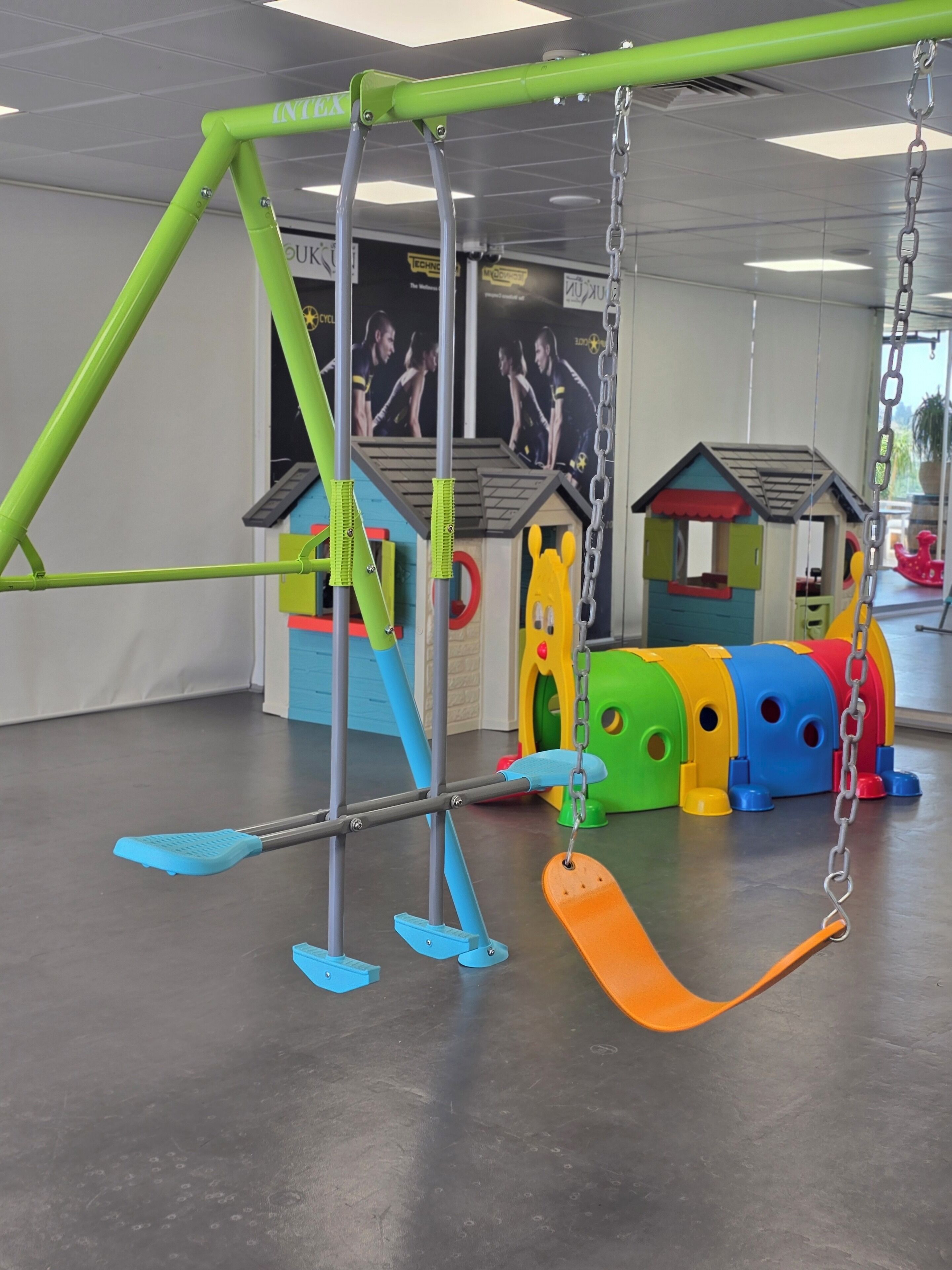 A children's play area with a swing set, colorful play structures, and a slide.