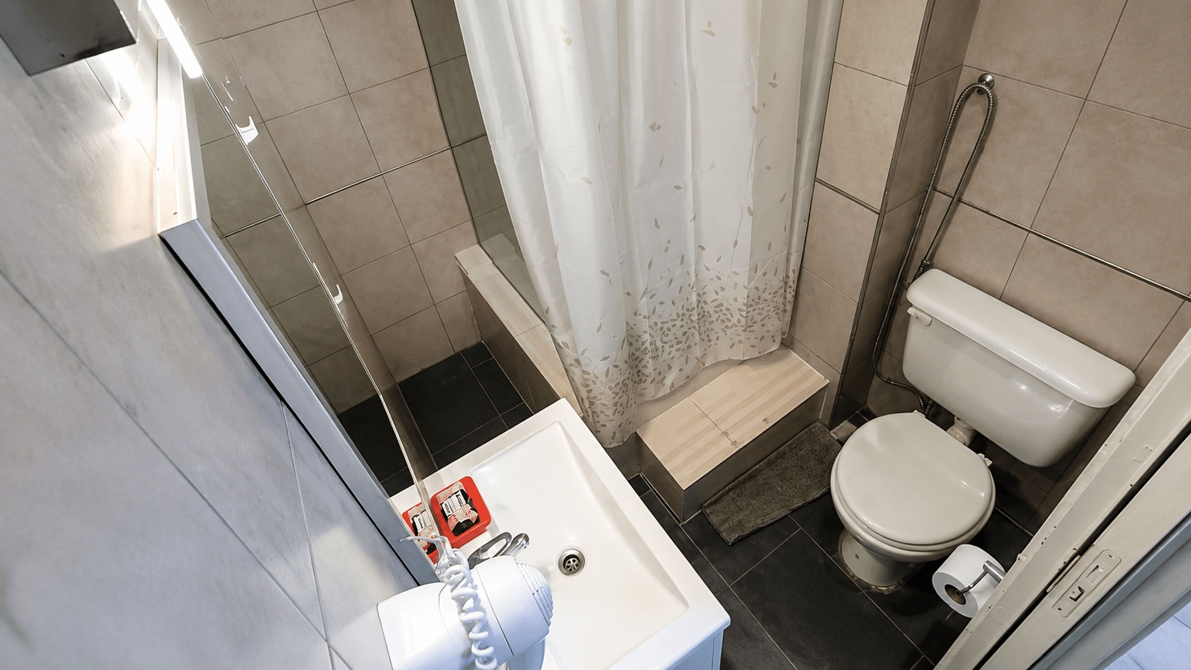 A bathroom with a shower, toilet, and sink.