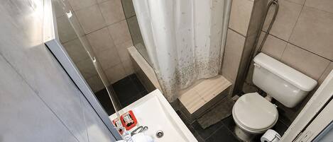 A bathroom with a shower, toilet, and sink.