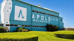 A large building with a prominent 'APOLO BALNEARIO' sign, featuring a large 'A' logo, multiple windows, and a flat roof. - Casa Colinas (Mar del Plata)