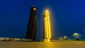 Two tall buildings with illuminated windows at night. - Amara Suites - Eko Atlantic (Lagos)