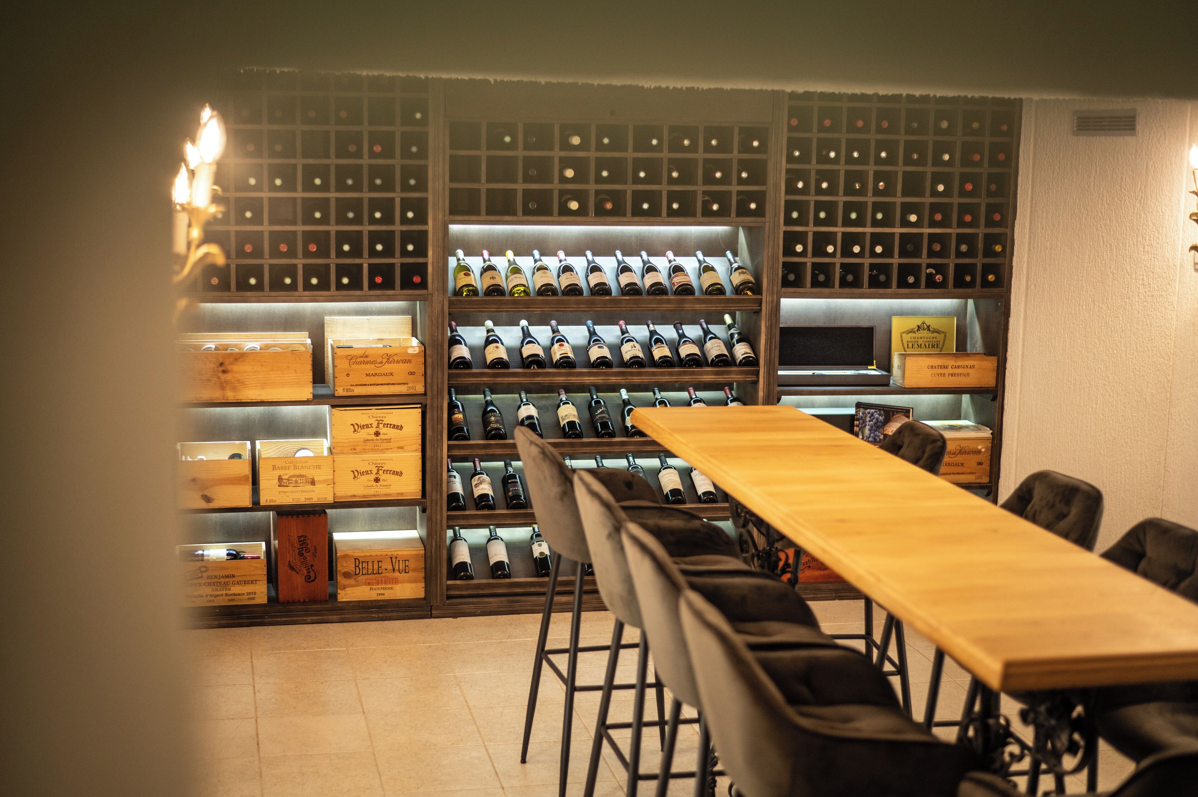 A wine cellar with wooden shelves and a long table.