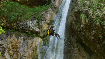 A person rappelling down a waterfall.