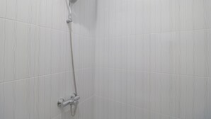 A shower with a handheld showerhead and a wall-mounted faucet. - RedDoorz Plus Near Kepri Mall (Batam)