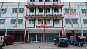 A building with a sign reading "RedDoorz" and another sign for "Gereja Shalom". - RedDoorz Plus Near Kepri Mall (Batam)