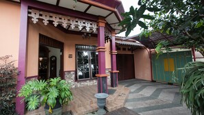 A building with a traditional architectural style, featuring a porch with steps and a decorative balustrade. - RedDoorz near Stasiun Kota Baru Malang (Malang)