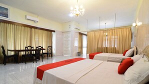 A hotel room with two beds, a dining area, and a bathroom. - RedDoorz Plus @ Laweyan (Surakarta)