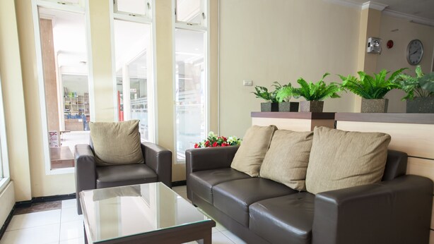 Una sala de estar con una mesa de centro de vidrio, dos sofás y plantas en macetas.