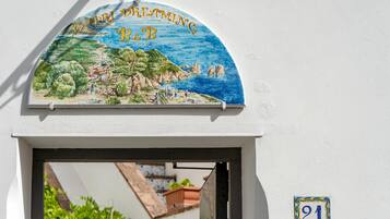 A sign with a coastal landscape and the text "Capri Dreaming B&B".