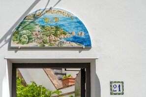 Placa com paisagem costeira e o texto 'Capri Dreaming B&B'.
