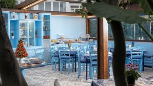 Un espace repas avec des meubles bleus et un buffet.