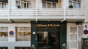 A building with a black storefront labeled "Marasia" and a balcony above the entrance. - Maresía Canteras Urban (Las Palmas de Gran Canaria)