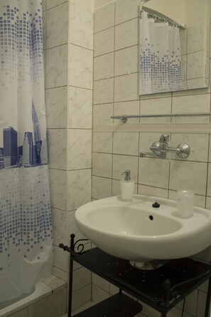 Economy driepersoonskamer | Badkamer | Een douche, gratis toiletartikelen, een haardroger, handdoeken