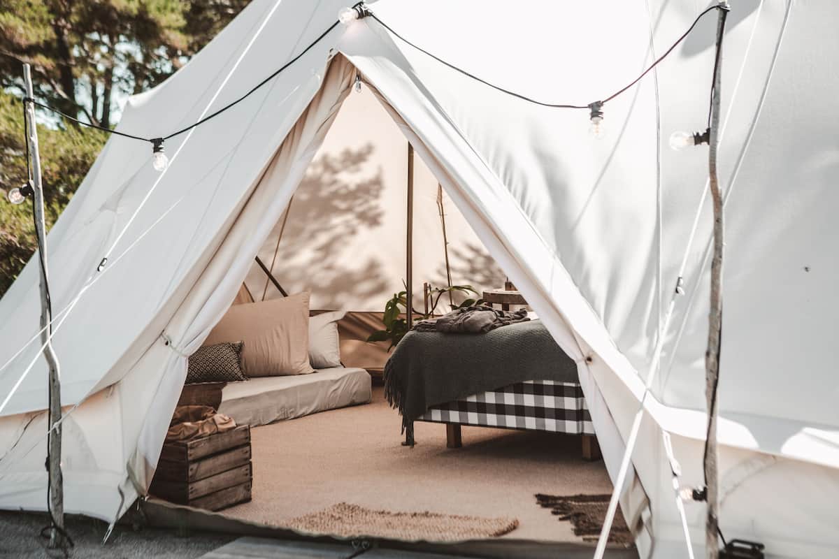 A tent with a bed, pillows, and a blanket inside.