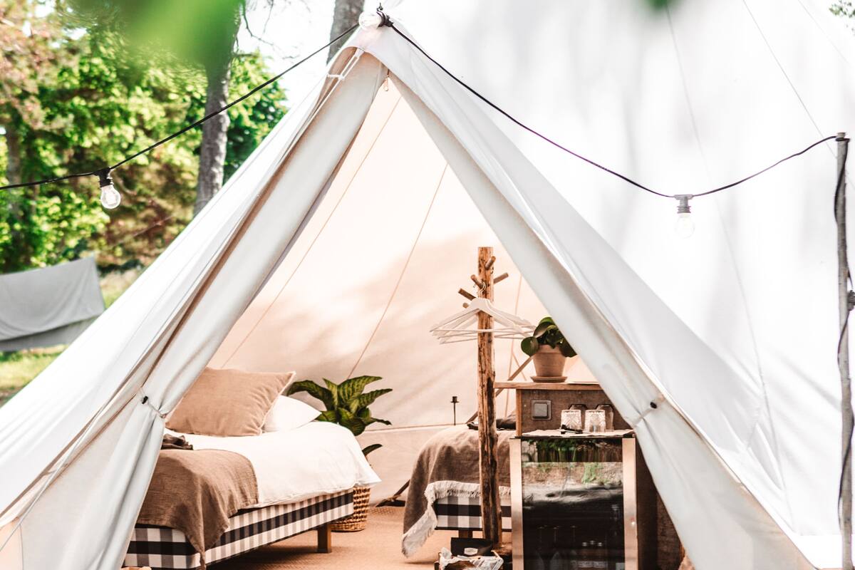 A tent with a bed, a small table, and a heater inside.