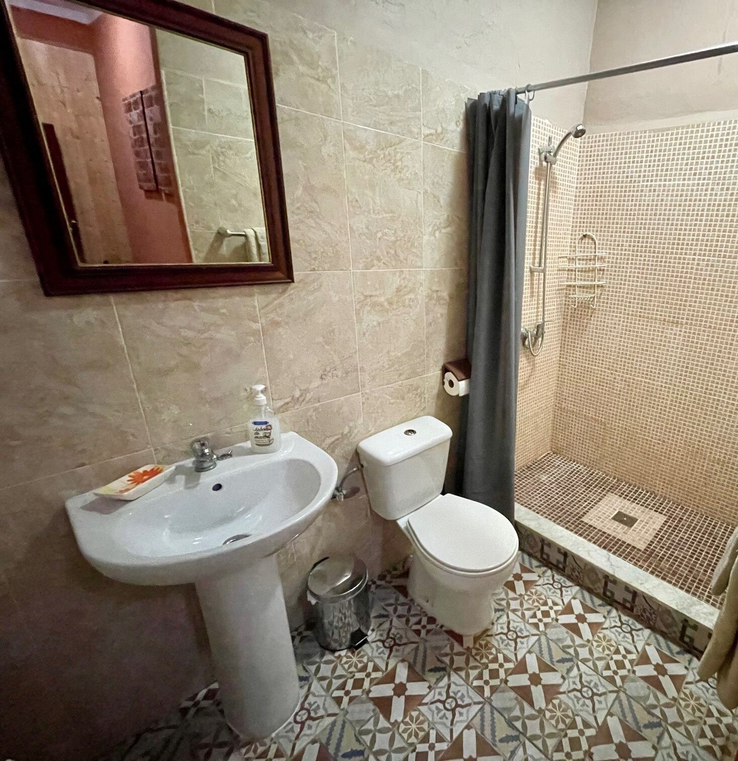 A bathroom with a sink, toilet, and shower.