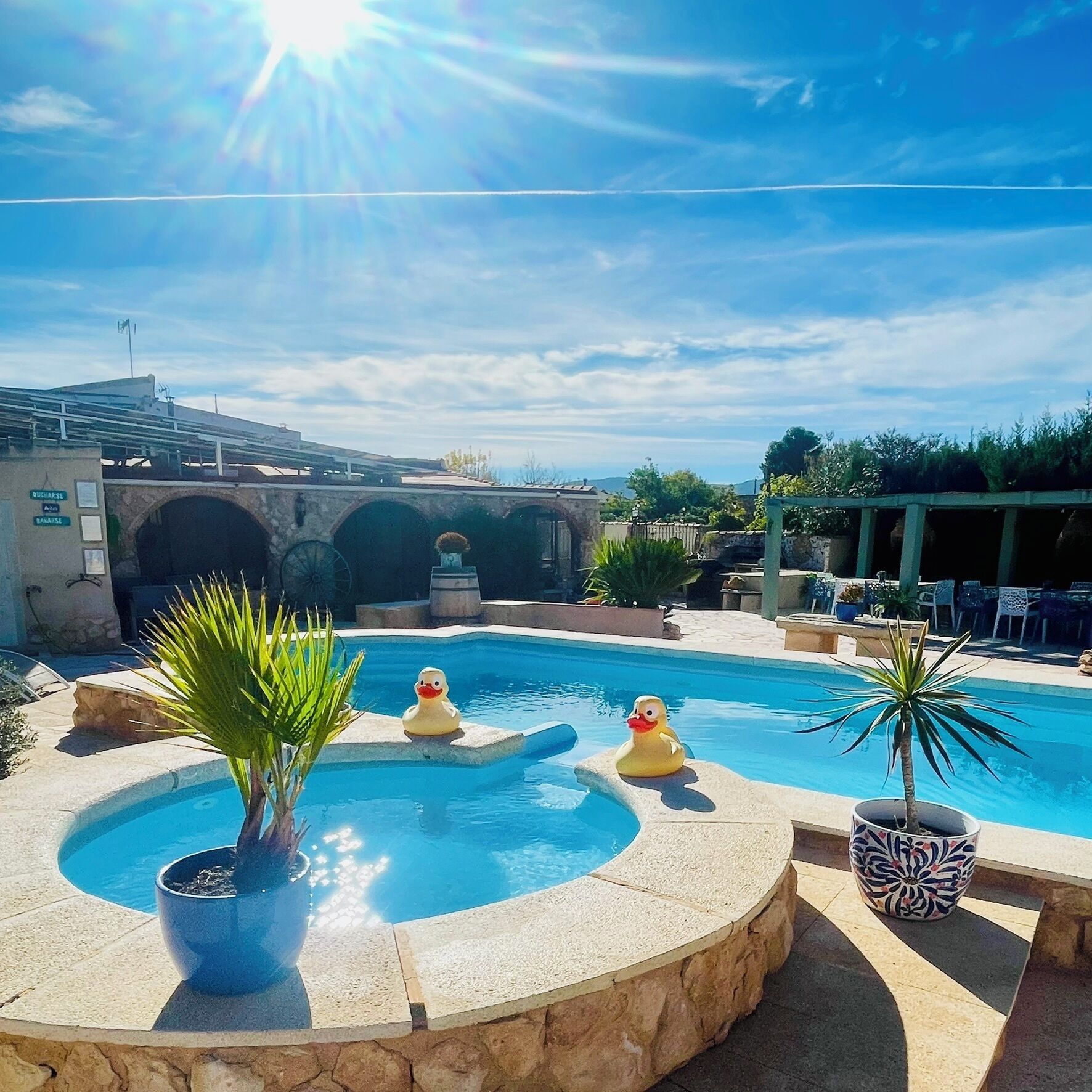 Een buitenzwembad, parasols bij het zwembad en ligstoelen