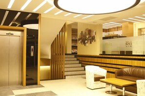 A modern hotel lobby with a reception desk, seating area, and an elevator. - Bent Hotel (Kocasinan)