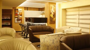 A modern living room with a sofa, armchairs, a coffee table, and a TV. - Bent Hotel (Kocasinan)