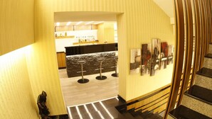 A modern kitchen with a bar area, featuring a stone backsplash, wooden stools, and a variety of kitchen appliances. - Bent Hotel (Kocasinan)