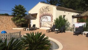 Un edificio con un mural, asientos al aire libre y una pared de piedra.