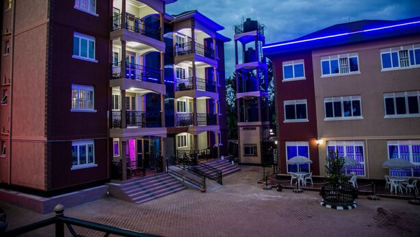 A multi-story hotel with balconies, outdoor seating, and a courtyard. - Red Sox Hotel (Seeta)
