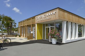 A modern building with a wooden facade and large windows. - Camping Les Places Dorees (Saint-Jean-de-Monts)