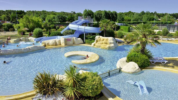 Ein Wasserpark mit großem Pool, Rutschen und Felsformationen.