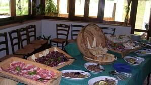 A buffet table with various food items and utensils. - Sas Abbilas (Bonorva)