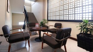 Una sala de conferències amb quatre cadires, una taula petita i una planta en test.