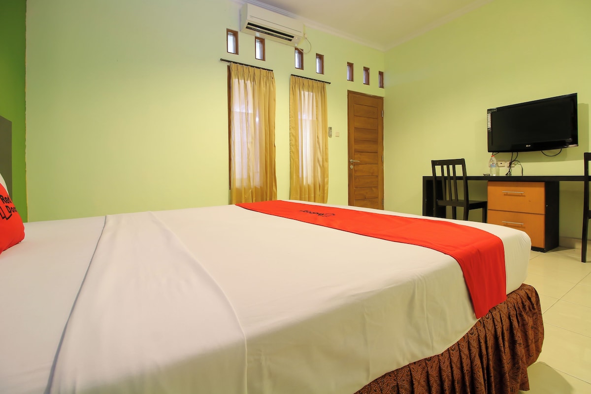 Une chambre d’hôtel équipée d’un lit, d’un bureau, d’une chaise, d’une télévision et d’une armoire.
