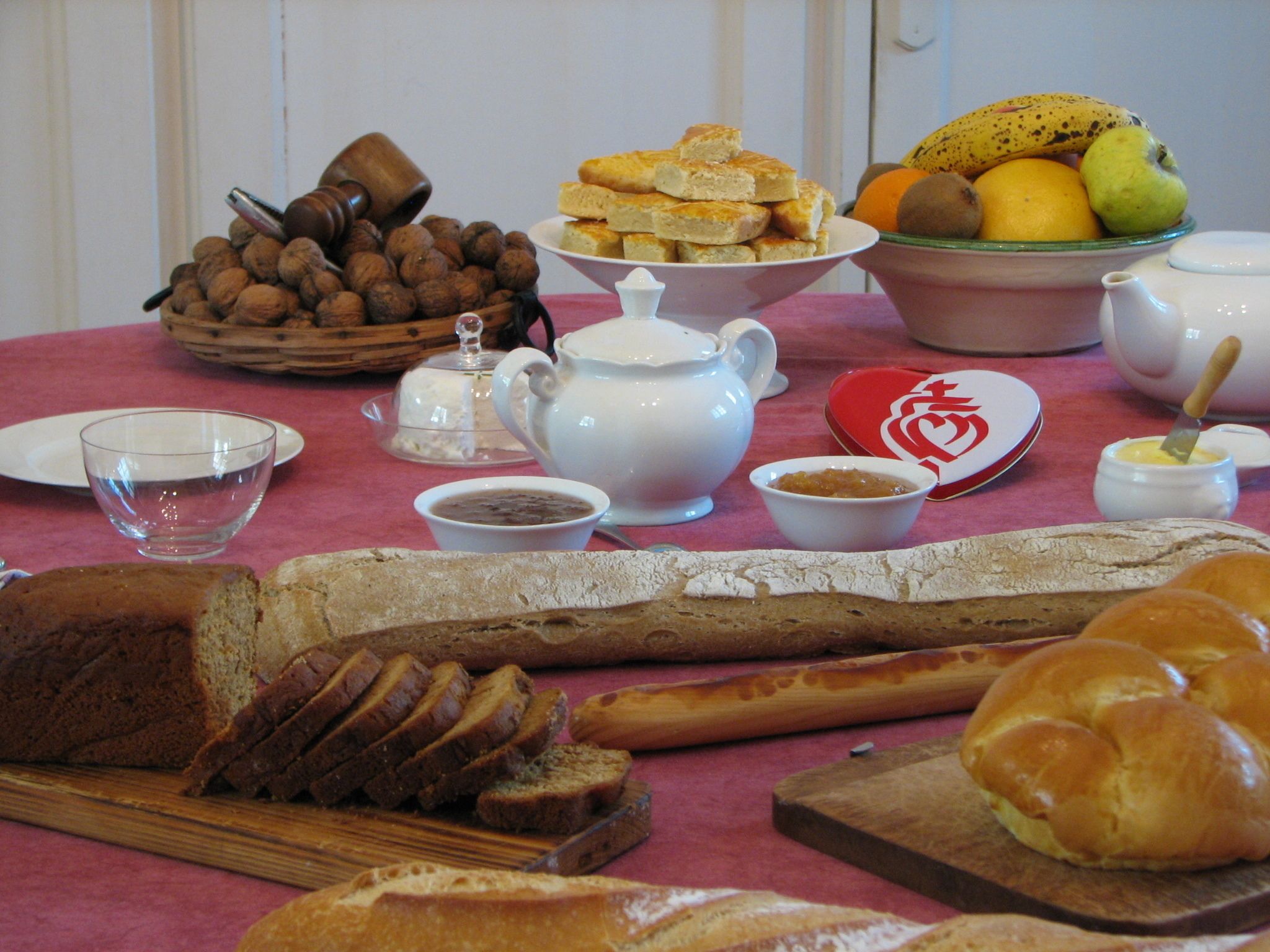 Una mesa dispuesta con diversos alimentos, como pan, pasteles y frutas.