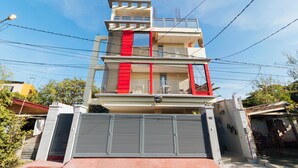 Un immeuble à plusieurs étages doté de balcons et d’une entrée sécurisée par un portail.