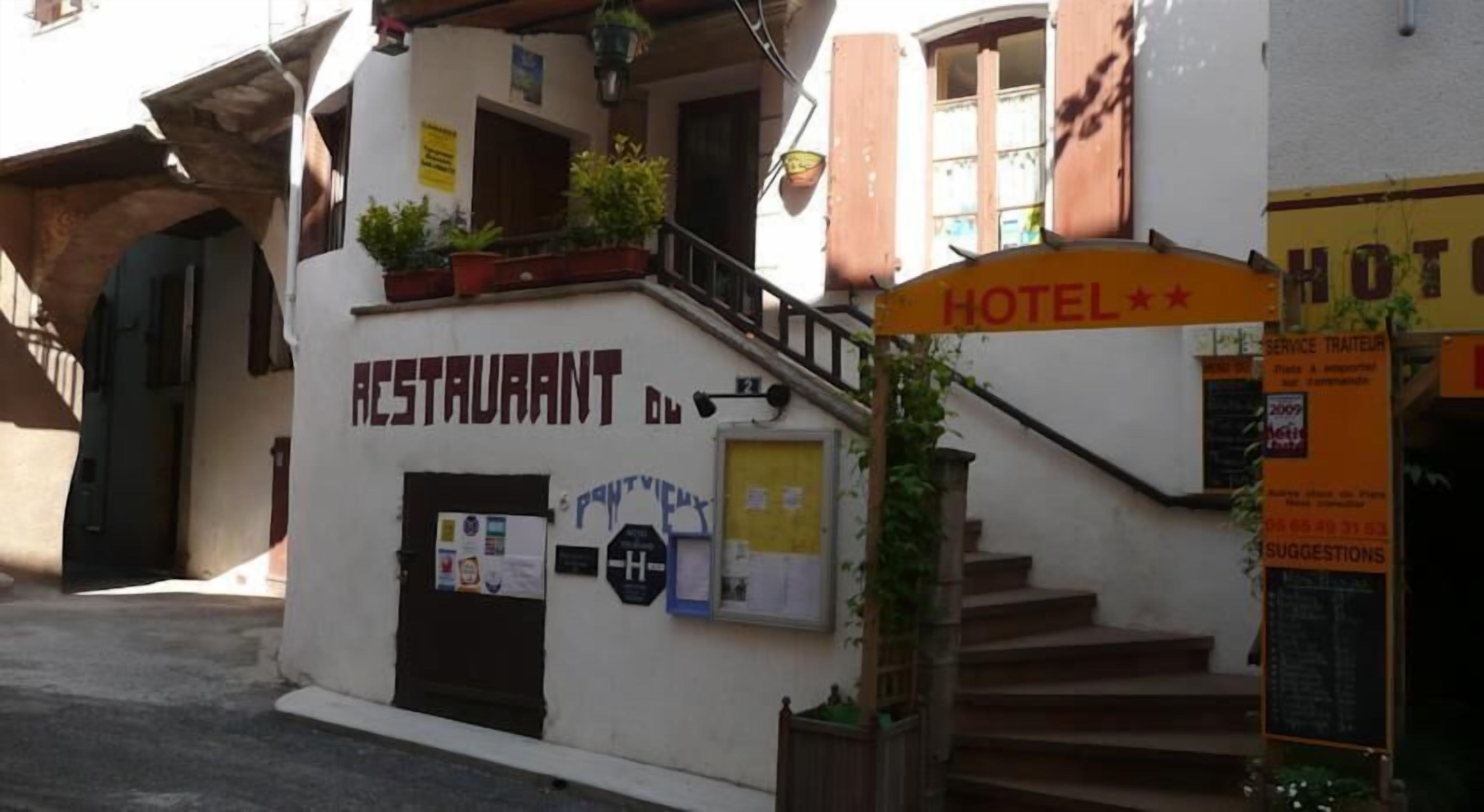 Un immeuble avec une enseigne indiquant la présence d’un restaurant et d’un hôtel.