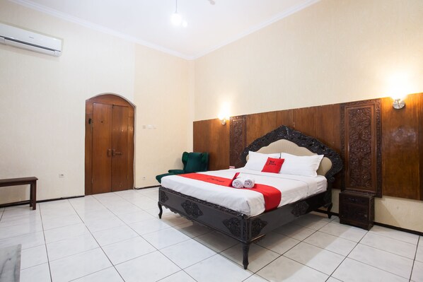 A neatly arranged bedroom with a bed, a bench, and a door.