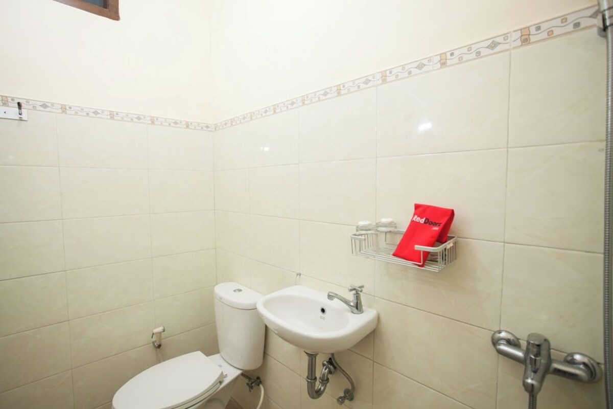 Une petite salle de bain avec des toilettes, un lavabo et une douche.