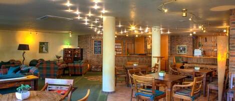 A cozy interior with a bar area, seating, and a reception desk.