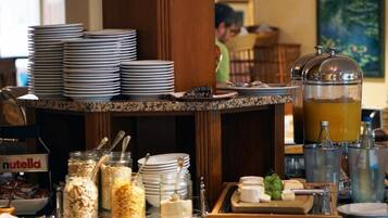 A buffet setup with various food items and utensils.