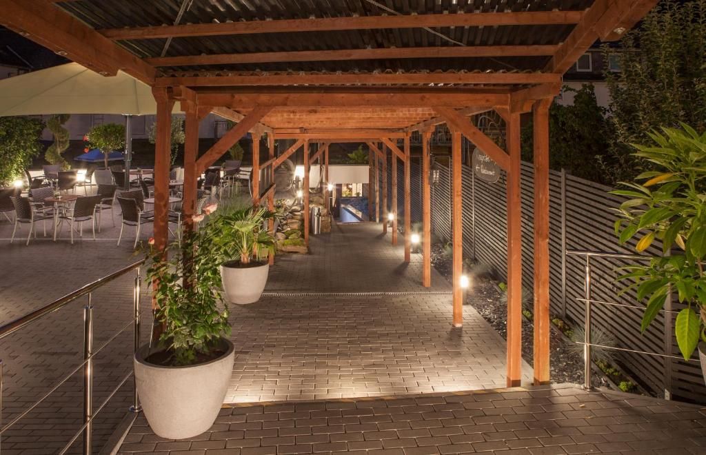 An outdoor covered patio area with seating and potted plants.