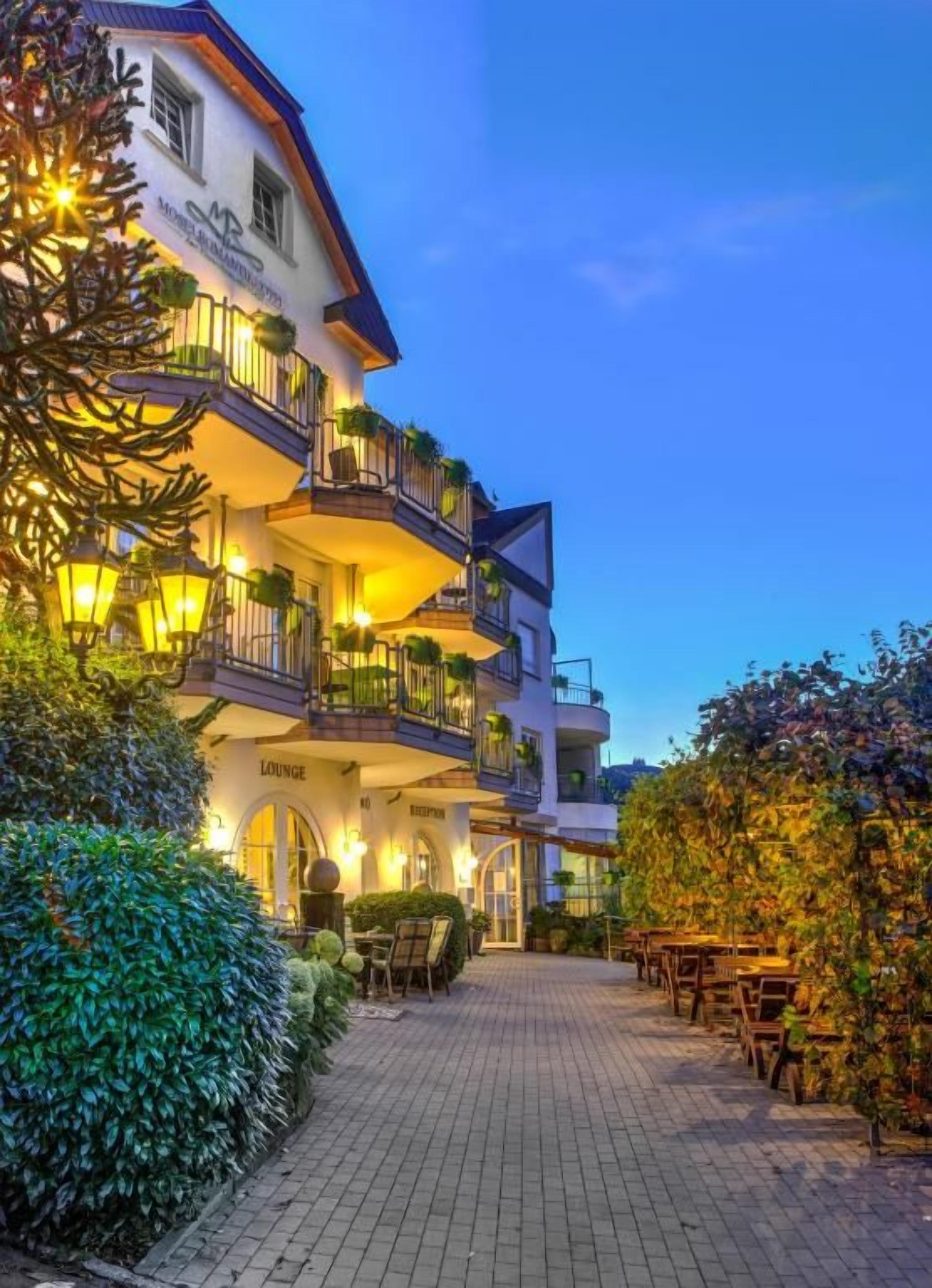 A hotel with multiple balconies, a lounge area, and outdoor seating.