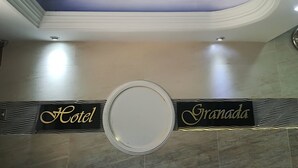A hotel entrance with a sign reading "Hotel Granada" and a circular mirror on the floor. - Hotel Granada Inn (Barranquilla)