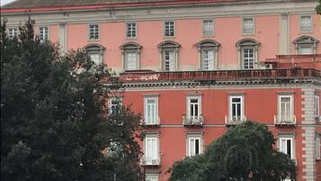 A multi-story building with a pink facade, multiple windows, and balconies.