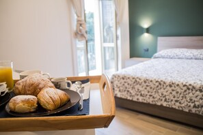 A breakfast tray with pastries and a glass of orange juice on a wooden tray in a hotel room. - Interno 10 Cavour (Naples)