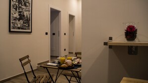 A dining area with a table set for breakfast, a chair, and a framed picture on the wall. - Interno 10 Cavour (Naples)