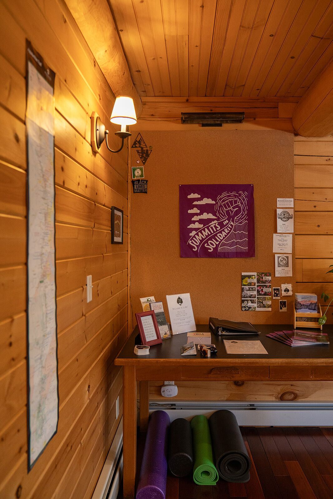 A wooden interior with a reception desk, yoga mats, and a poster on the wall.