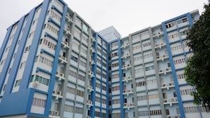 Een meerlaags gebouw met een blauw-witte kleurstelling, met balkons en airconditioning.