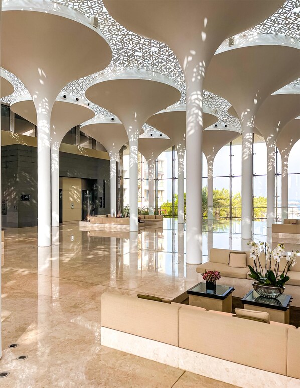 A spacious lobby with high ceilings, large windows, and modern architecture. - Kempinski Hotel Muscat (Muscat)